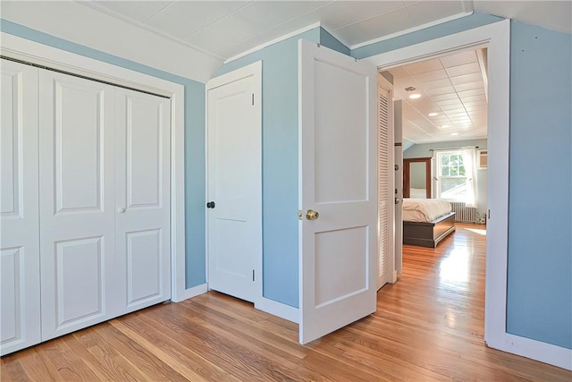 unfurnished bedroom featuring a closet, light hardwood / wood-style flooring, and vaulted ceiling