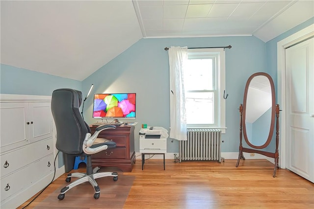 office space featuring radiator heating unit, light hardwood / wood-style floors, lofted ceiling, and ornamental molding