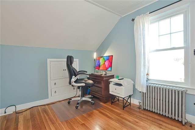 office with radiator heating unit, lofted ceiling, and light wood-type flooring