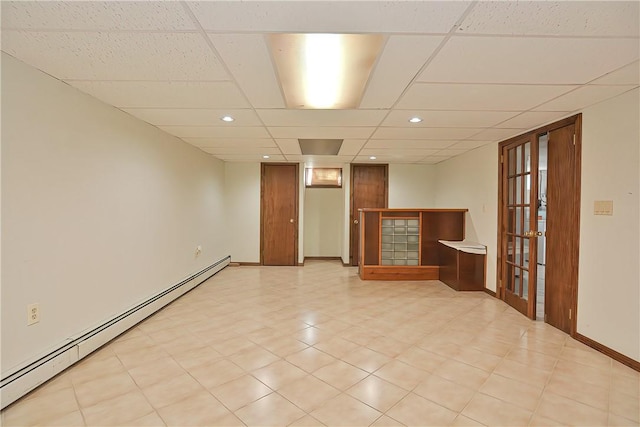 spare room featuring a drop ceiling, french doors, and a baseboard heating unit