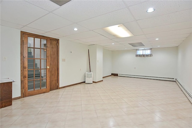 basement featuring a paneled ceiling and a baseboard radiator