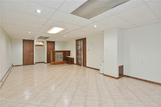 interior space featuring baseboard heating and a drop ceiling