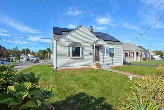 bungalow-style house with a front yard and solar panels