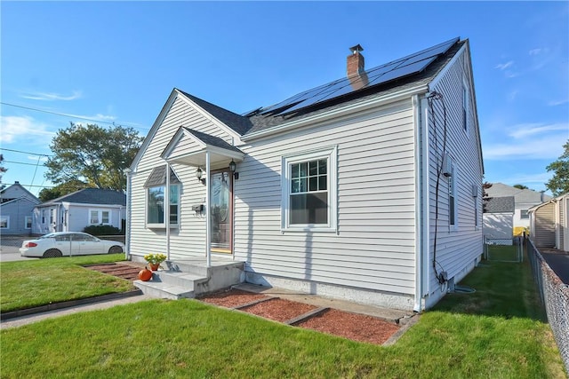 view of front of house with a front yard and solar panels