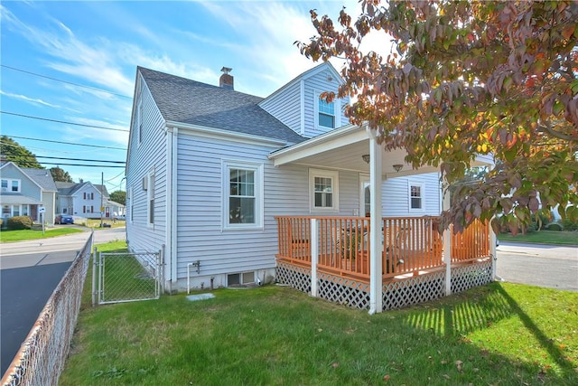 back of property with a lawn and a deck