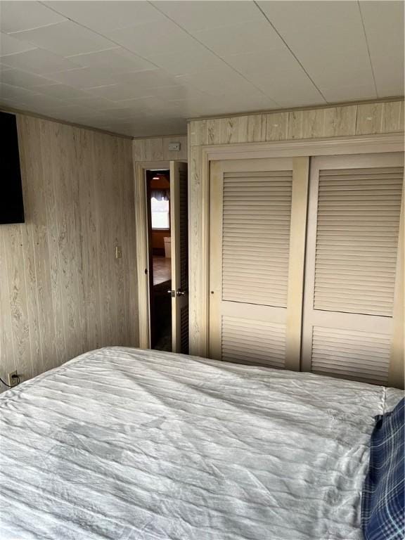 bedroom featuring a closet and wood walls