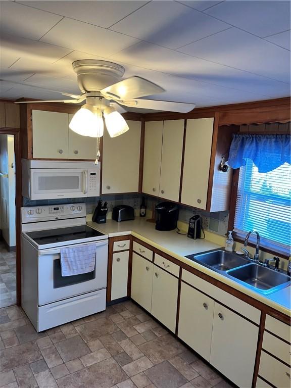 kitchen with white cabinets, white appliances, ceiling fan, and sink