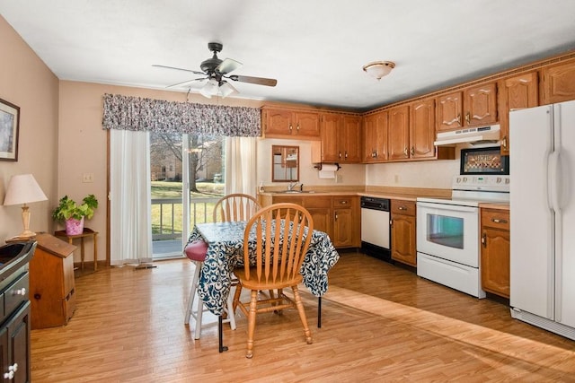 kitchen featuring light wood-type flooring, white appliances, ceiling fan, and sink