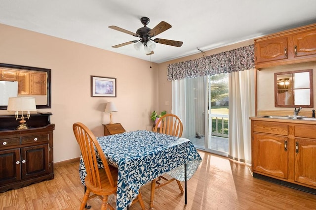 dining area with light hardwood / wood-style flooring, ceiling fan, and sink