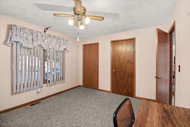 carpeted bedroom with ceiling fan and multiple closets