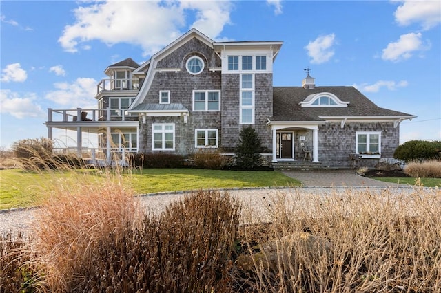 view of front of house with a balcony and a front lawn