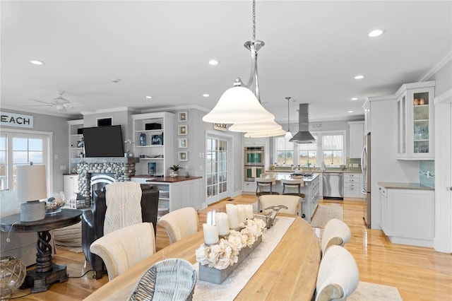 dining room with light hardwood / wood-style flooring, plenty of natural light, ornamental molding, and ceiling fan