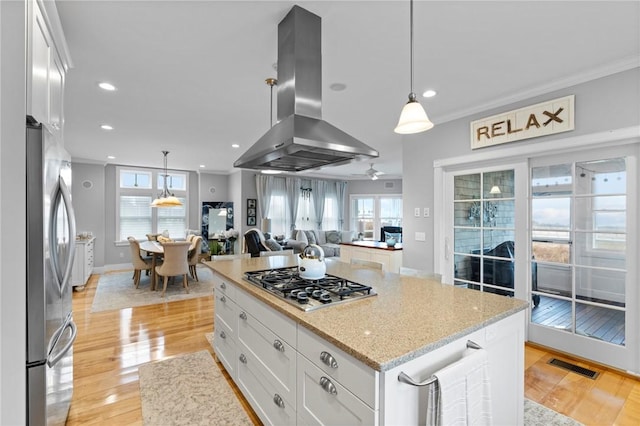 kitchen with extractor fan, light hardwood / wood-style flooring, white cabinetry, and stainless steel appliances