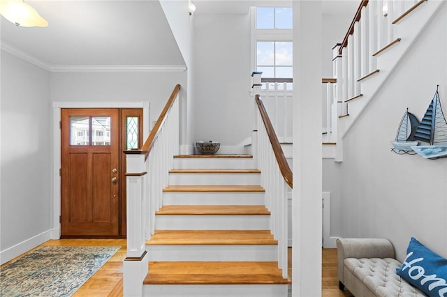 foyer entrance featuring light hardwood / wood-style flooring, plenty of natural light, and crown molding