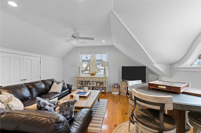 living room featuring ceiling fan, light hardwood / wood-style flooring, and vaulted ceiling