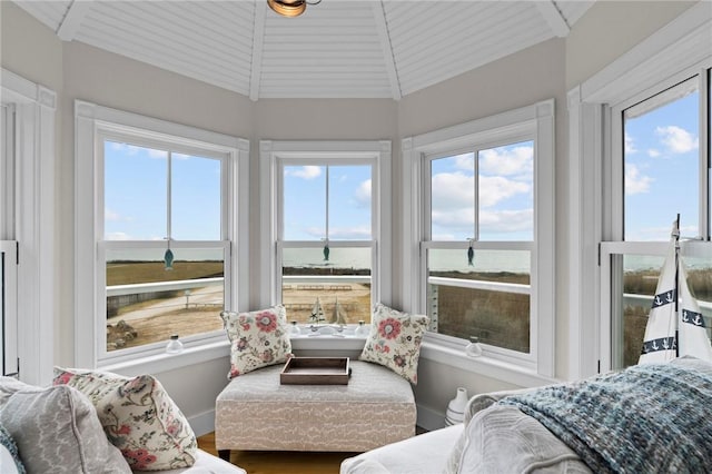 sunroom with wooden ceiling, a water view, and lofted ceiling with beams