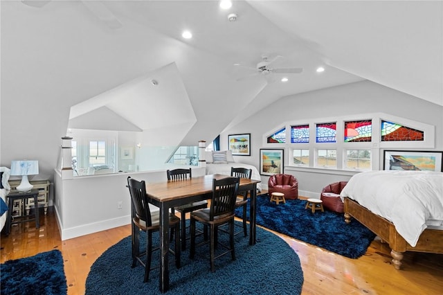 dining room featuring ceiling fan, light wood-type flooring, and vaulted ceiling