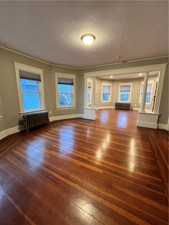 unfurnished living room with ornamental molding, dark wood-type flooring, and radiator