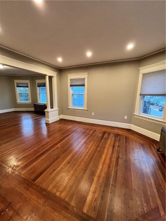 unfurnished living room with dark hardwood / wood-style floors and ornamental molding