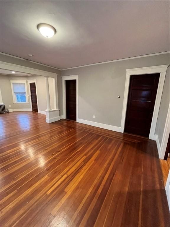 unfurnished living room featuring dark hardwood / wood-style flooring and radiator heating unit