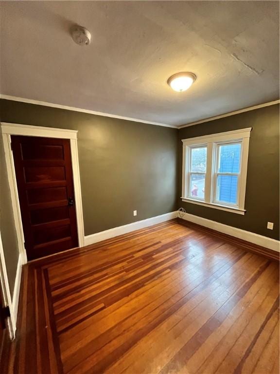 unfurnished room with hardwood / wood-style flooring and ornamental molding