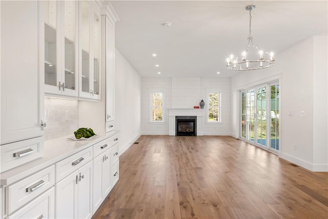 unfurnished living room featuring light hardwood / wood-style flooring and a notable chandelier