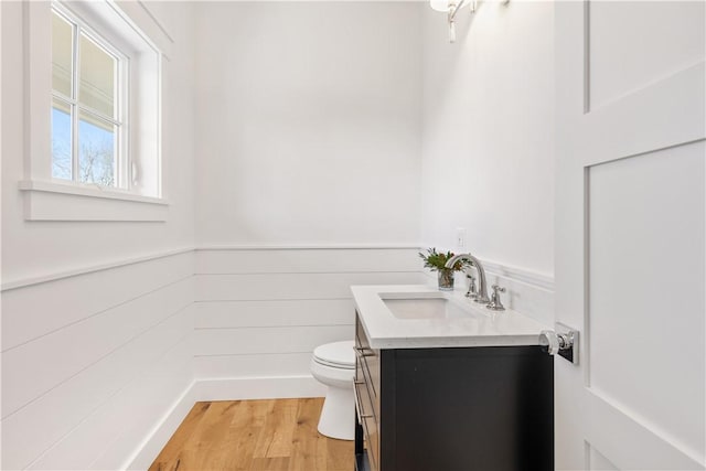 bathroom with hardwood / wood-style flooring, vanity, and toilet