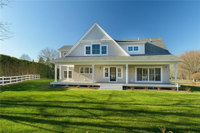 rear view of property featuring a lawn and covered porch