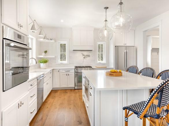 kitchen featuring a kitchen island, white cabinets, a kitchen breakfast bar, light hardwood / wood-style floors, and stainless steel appliances