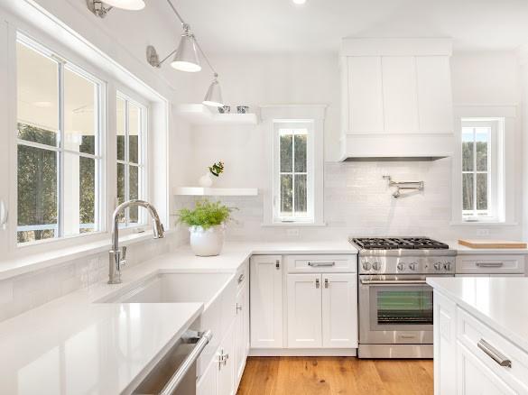 kitchen featuring sink, custom range hood, light hardwood / wood-style floors, high end stove, and white cabinets