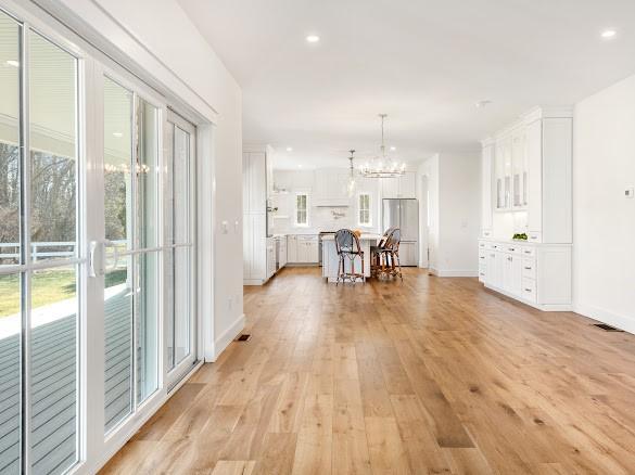 interior space featuring plenty of natural light, a notable chandelier, and light hardwood / wood-style floors