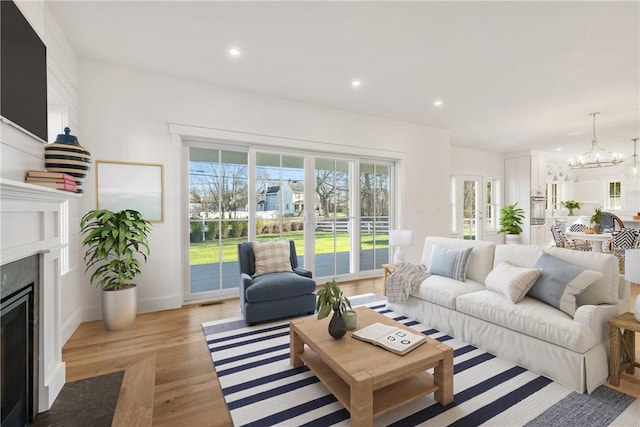 living room with a notable chandelier and light hardwood / wood-style flooring