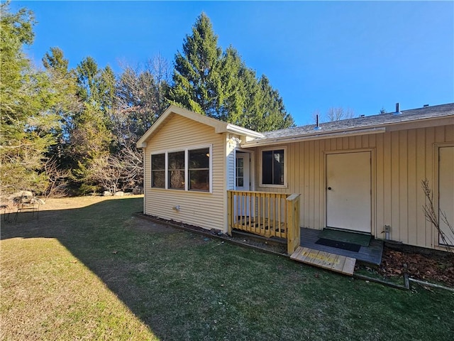 rear view of property featuring a lawn