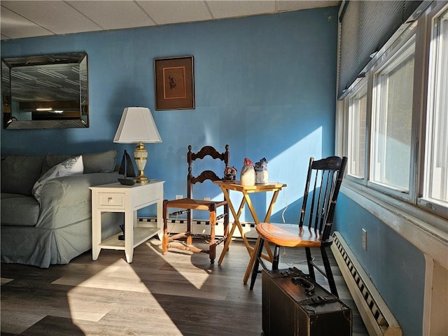 sitting room with hardwood / wood-style floors and a drop ceiling