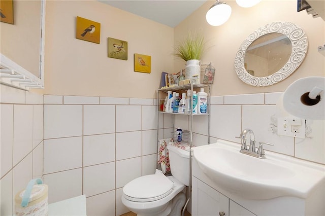 bathroom with vanity, toilet, and tile walls