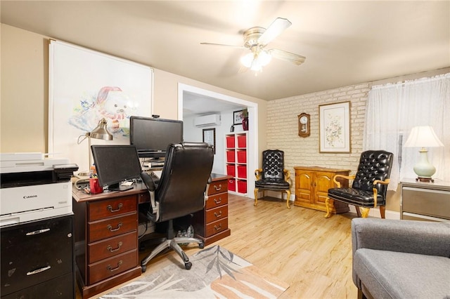 office area with an AC wall unit, ceiling fan, light hardwood / wood-style floors, and brick wall