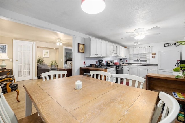 dining room with a textured ceiling, light hardwood / wood-style floors, and sink