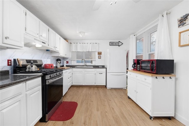 kitchen featuring sink, stainless steel gas stove, white cabinets, and white refrigerator