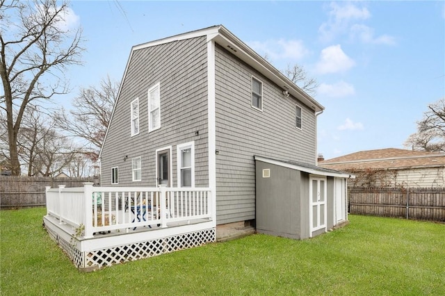 rear view of property with a lawn and a wooden deck