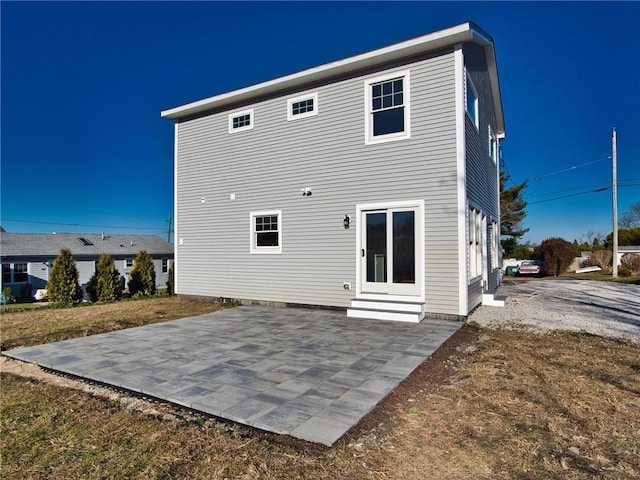 rear view of property with entry steps and a patio