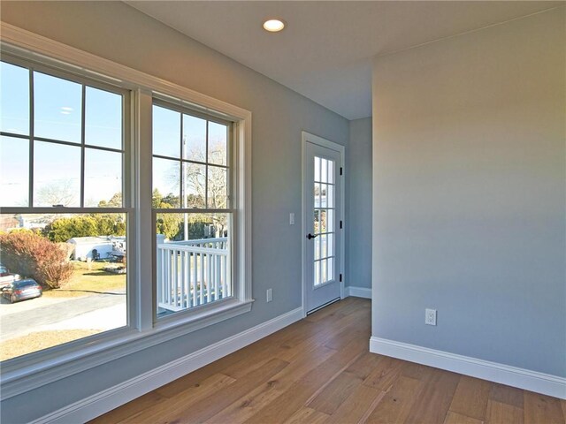 entryway featuring baseboards, recessed lighting, wood finished floors, and a healthy amount of sunlight