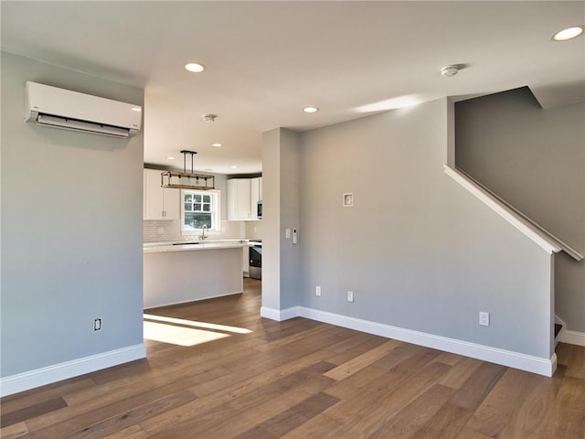 unfurnished living room with dark hardwood / wood-style floors and a wall mounted AC