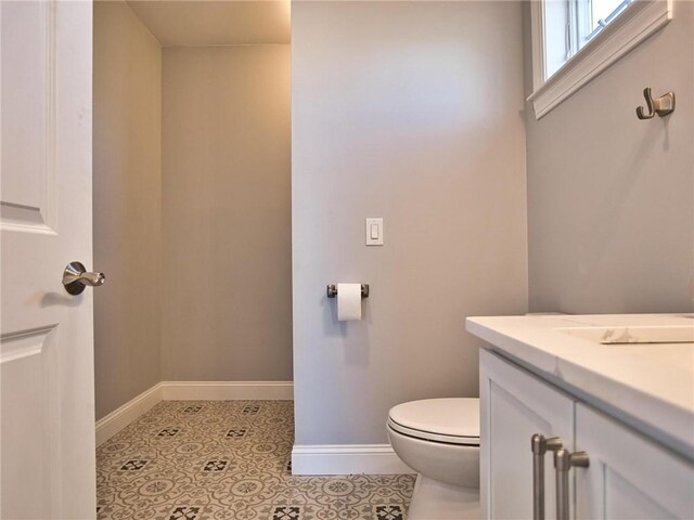 bathroom featuring toilet, vanity, and tile patterned flooring