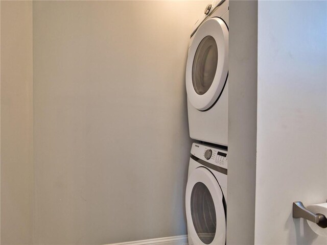 washroom featuring stacked washer and clothes dryer