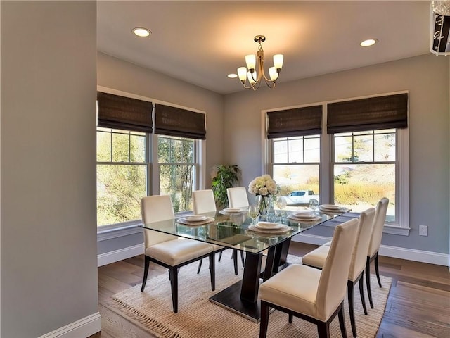 dining space with baseboards, recessed lighting, wood finished floors, and an inviting chandelier