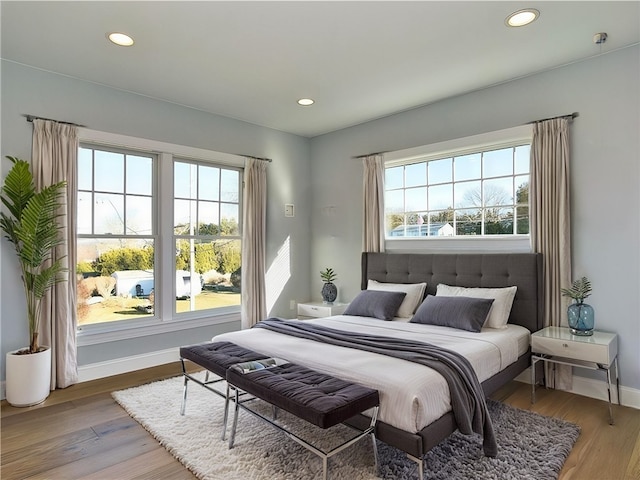 bedroom featuring baseboards, wood finished floors, and recessed lighting