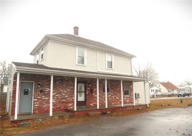 rear view of house featuring covered porch