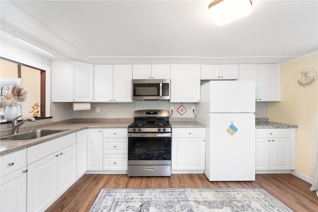 kitchen featuring white cabinetry, sink, light hardwood / wood-style floors, and appliances with stainless steel finishes