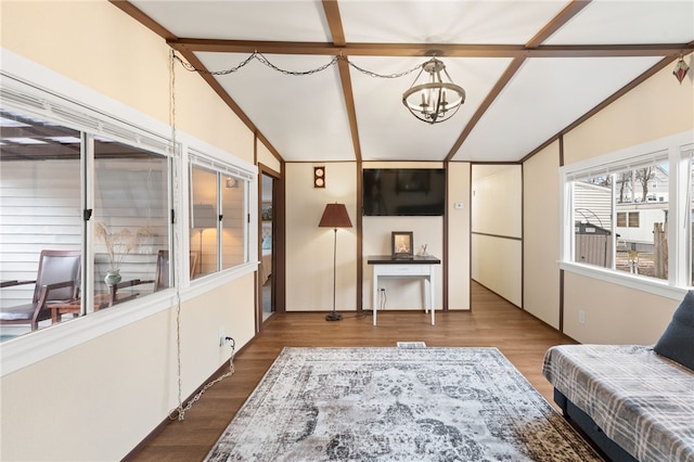 living room with lofted ceiling with beams, a chandelier, and hardwood / wood-style flooring