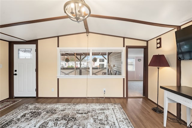 entrance foyer with lofted ceiling with beams, dark wood-type flooring, and an inviting chandelier